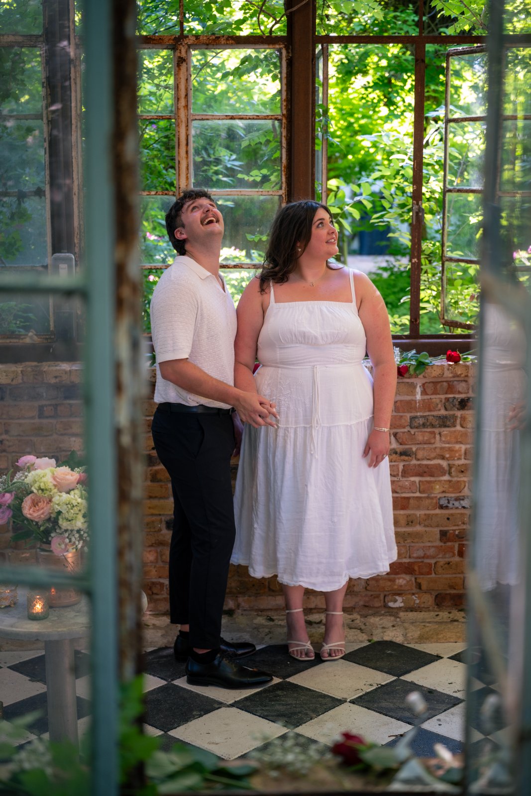 Romantic couple portrait inside a rustic greenhouse with natural light and greenery — taken by Zan Visuals.