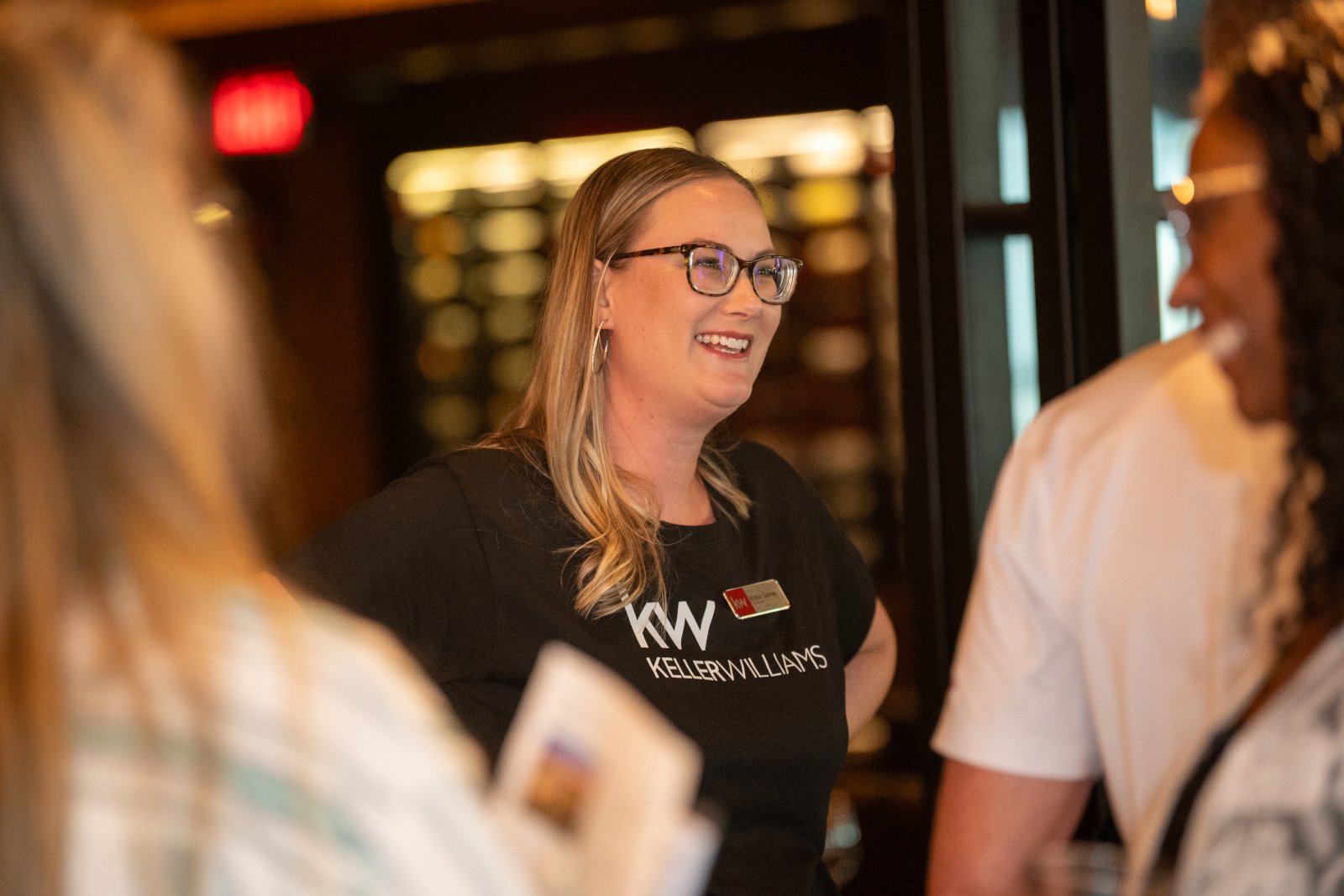 Guest interacting during the Brohan Real Estate event at Haywire, wearing a Keller Williams shirt in a warm networking atmosphere — photographed by Zan Visuals.