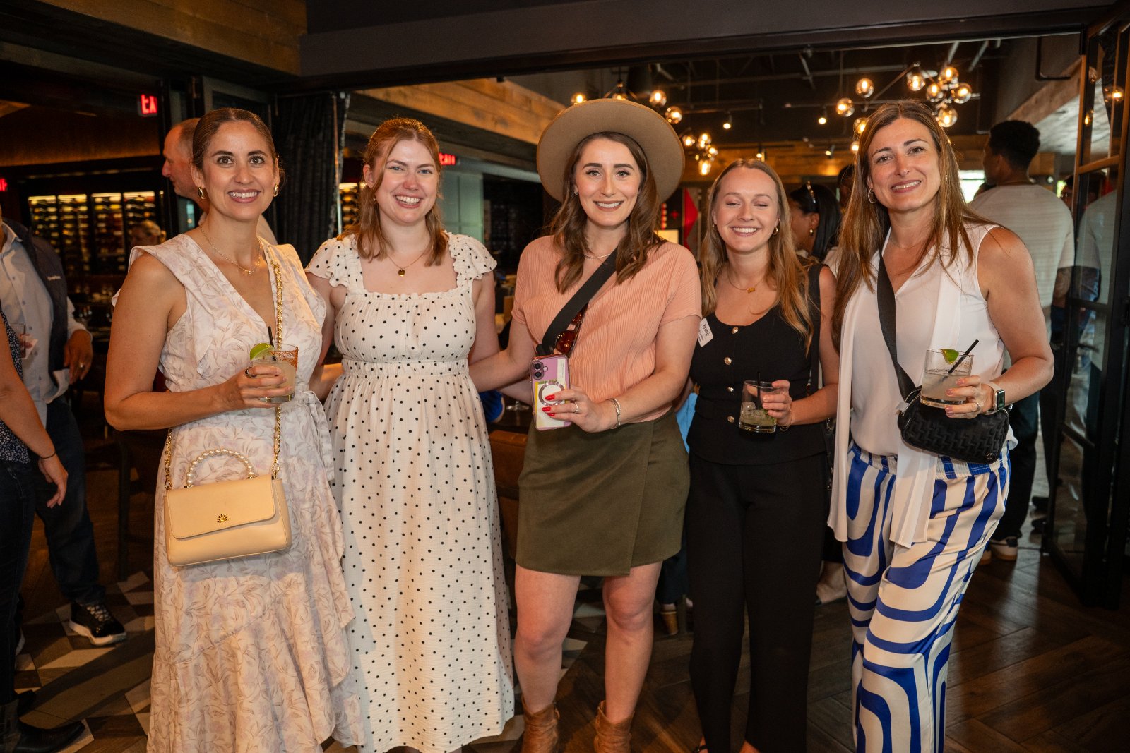 Group photo of guests enjoying the Brohan Real Estate event at Haywire, captured in a warm social atmosphere — photographed by Zan Visuals.