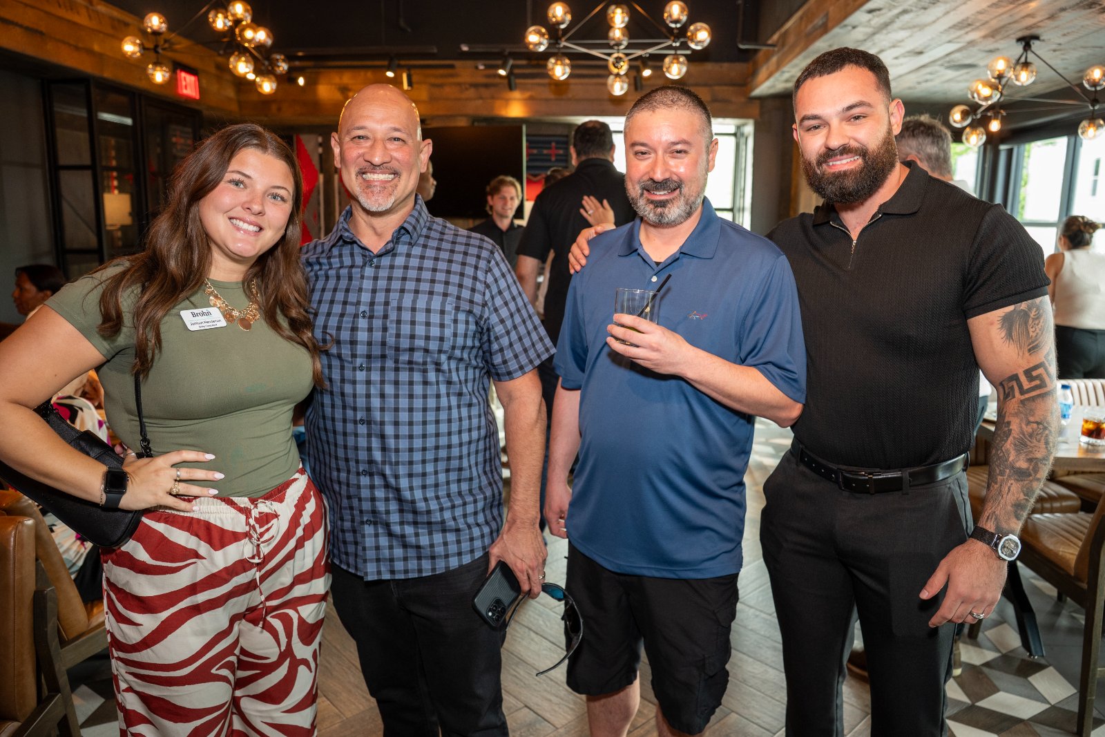 Group of guests posing together during the Brohan Real Estate event at Haywire, captured in a warm and lively atmosphere — photographed by Zan Visuals.