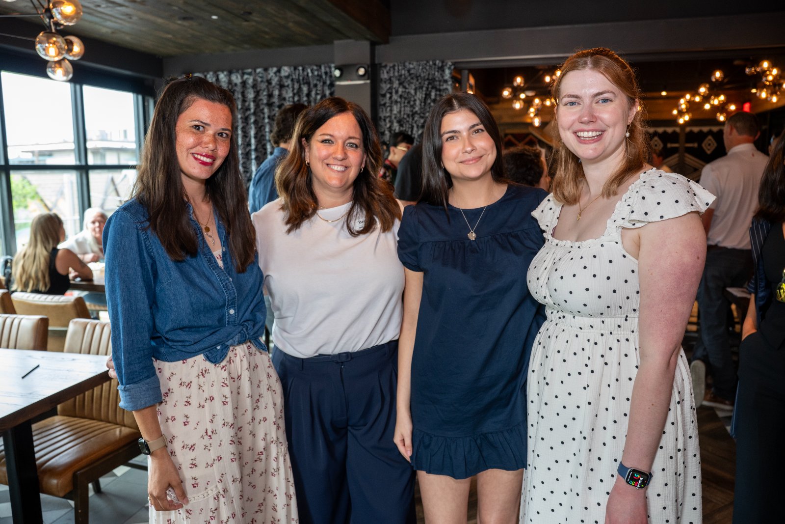 Group of guests posing together during the Brohan Real Estate event at Haywire, captured in a bright and welcoming atmosphere — photographed by Zan Visuals.