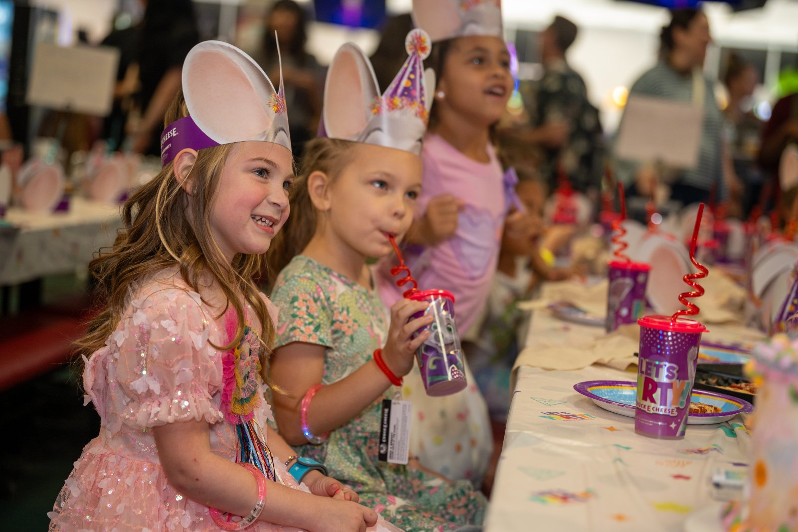 Children sitting at a decorated party table wearing themed hats and enjoying a fun birthday celebration — photographed by Zan Visuals.