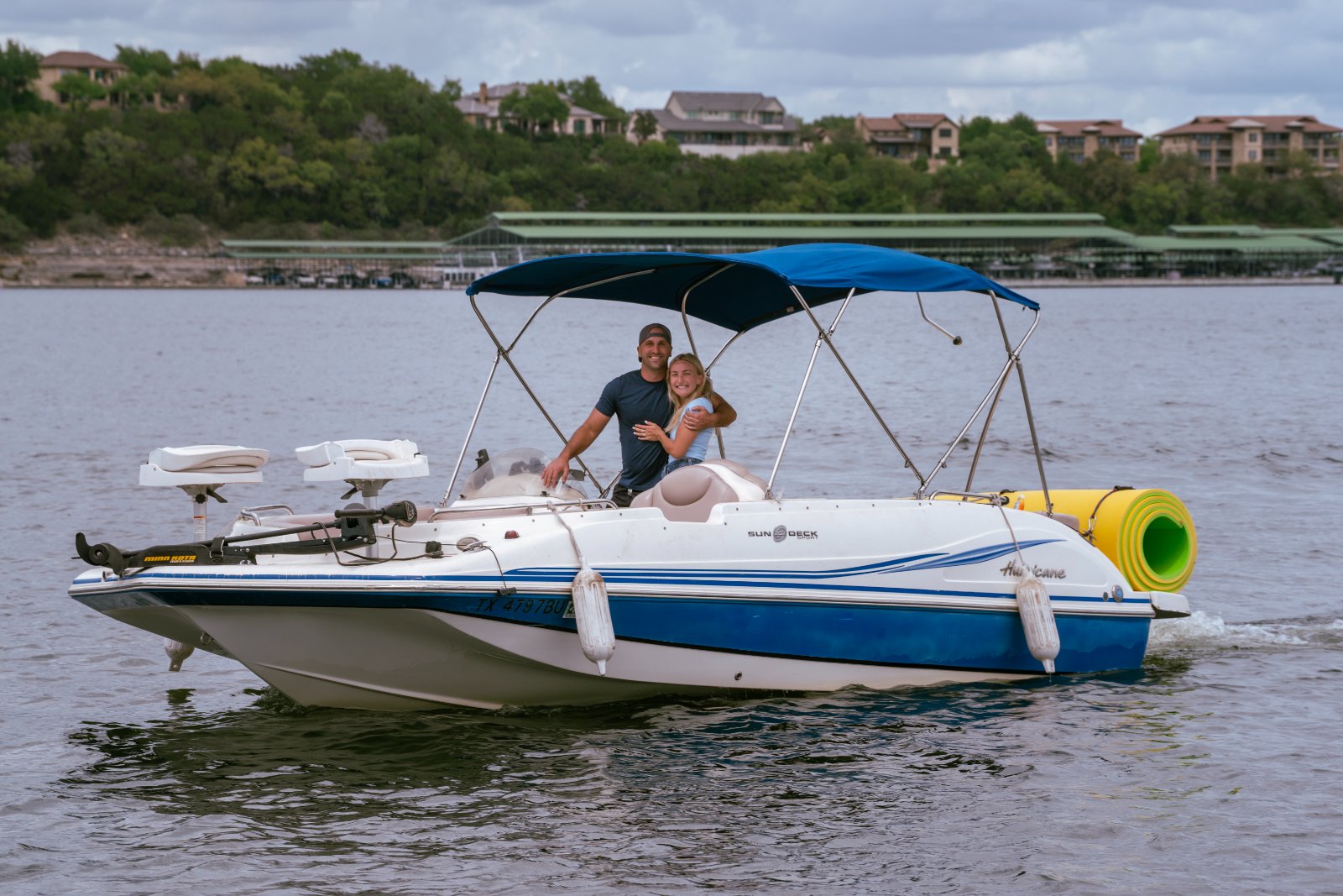 A couple sharing an intimate moment on a private boat during a planned proposal session, surrounded by lake views and soft natural light — captured by Zan Visuals.