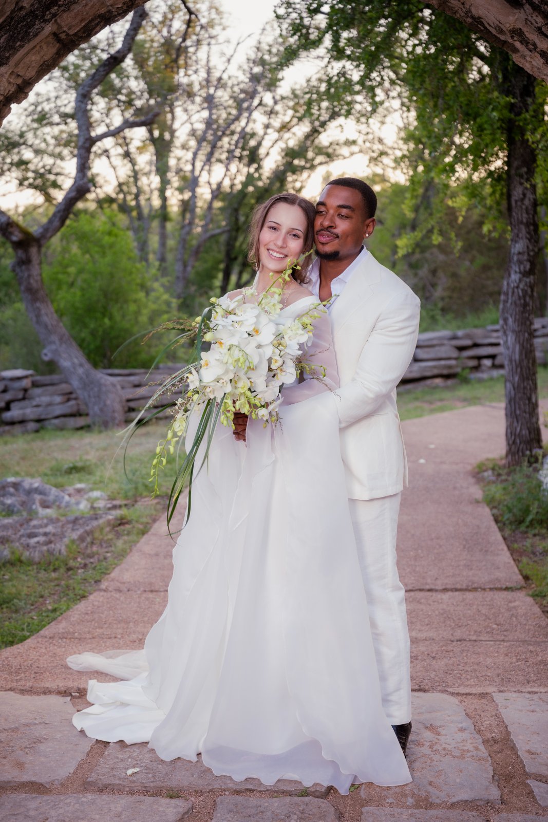 A bride and groom standing together outdoors during their wedding portrait session, photographed by Zan Visuals in Austin, Texas.
