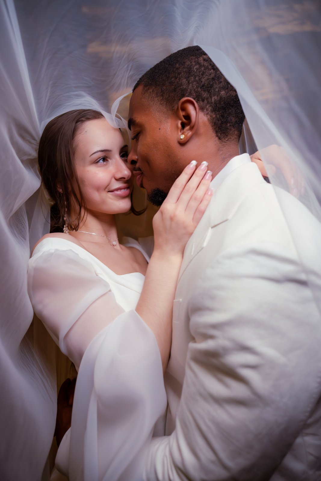 A romantic wedding portrait of a couple standing under a sheer veil, photographed by Zan Visuals in Austin, Texas.