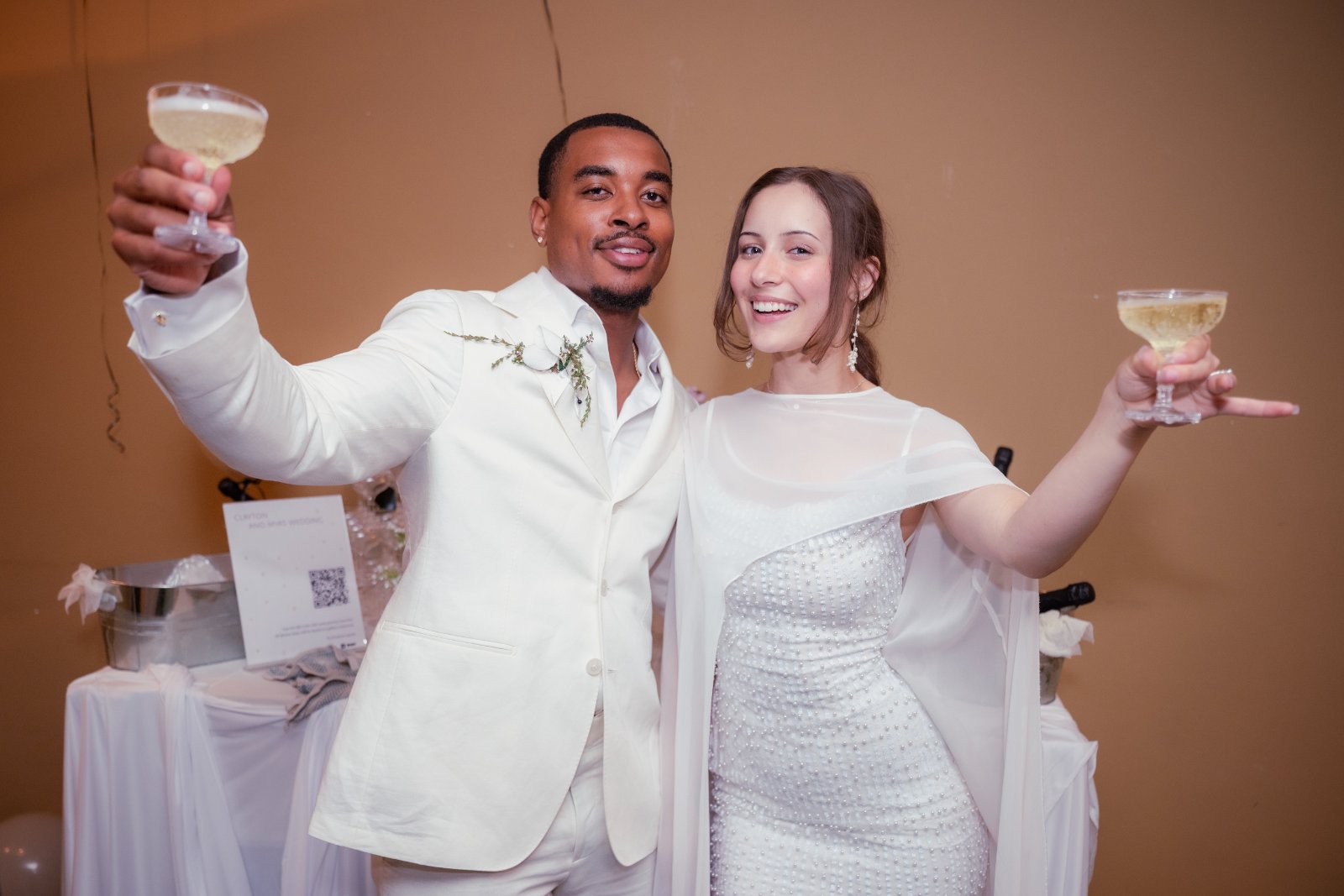 A bride and groom raising champagne glasses in a joyful wedding toast, photographed by Zan Visuals in Austin, Texas.