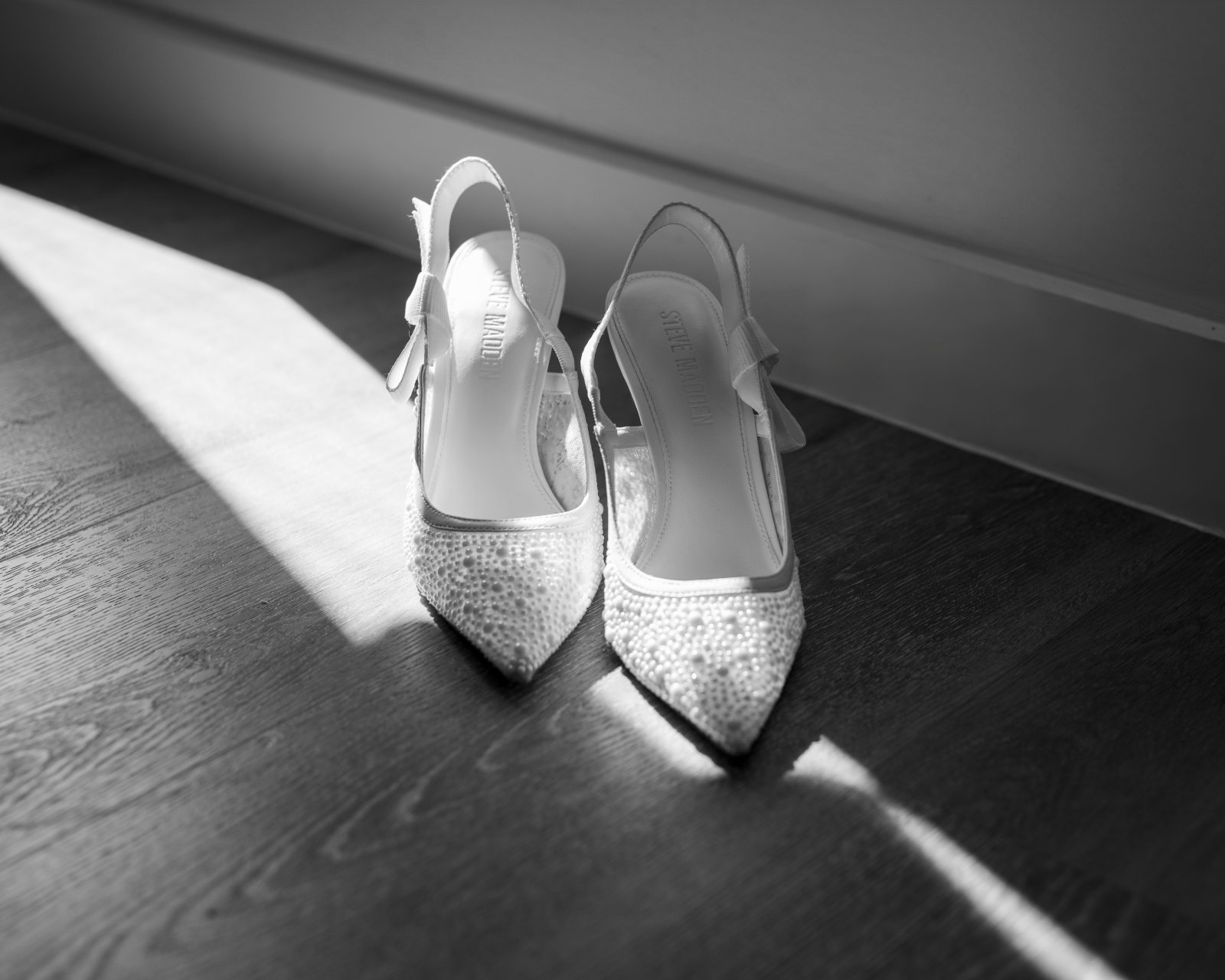 Elegant bridal heels with sparkling embellishments photographed in dramatic light and shadow, captured by Zan Visuals.